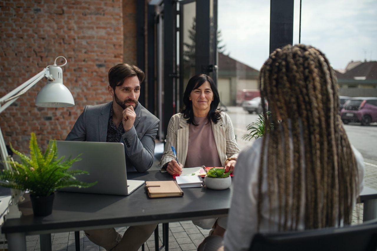 rear-view-of-young-woman-having-job-interview-in-office-business-and-career-concept