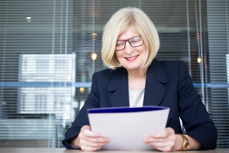 Positive senior HR worker holding personal file